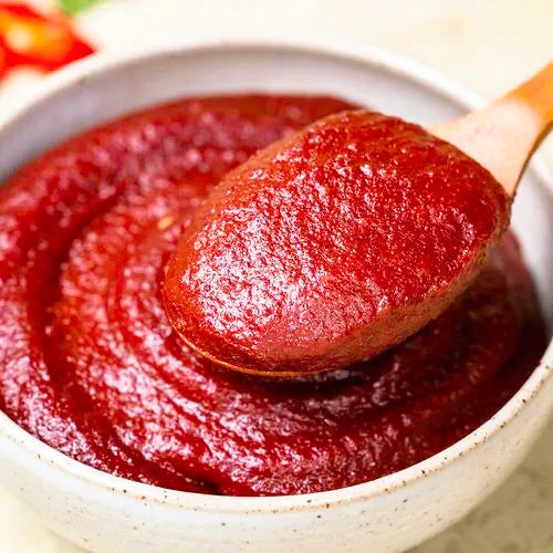 Red chili paste in a bowl with a wooden spoon