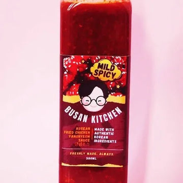 A bottle of Yangneom Korean Chicken Sauce with a label featuring a cartoon character and red spicy chili graphics.