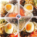 Plated Bibimbap - vegetables, and eggs in a clear container.