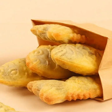 Puff bungeoppang in a brown paper bag on a beige background