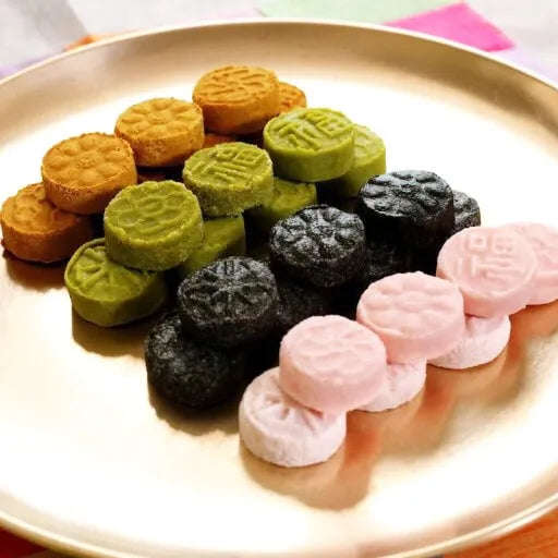 Assorted colorful Korean cookies on a gold plate
