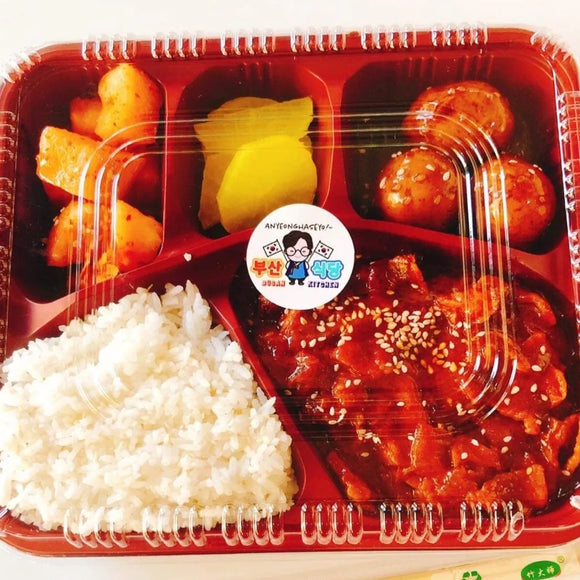 A packaged meal consisting of white rice, sweet and spicy pork stir-fry, and various side dishes in a red lunchbox.