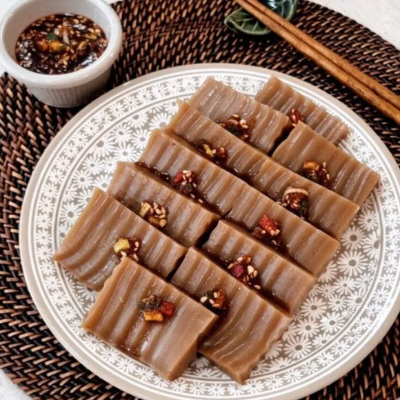 A plate of Dotorimuk, a traditional Korean side dish, garnished with nuts and served with chopsticks.