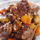 Stewed meat with carrots and pine nuts on a white plate