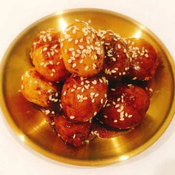 Baby potatoes with sesame seeds on a gold plate