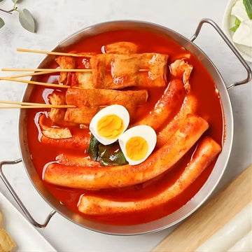 Hot pot with skewered vegetables and boiled eggs in a red broth