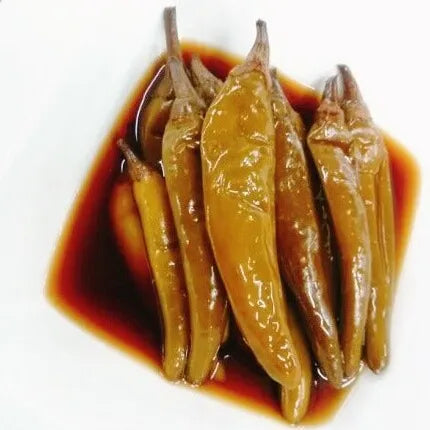 A plate containing pickled Korean green chili peppers in a soy-based sauce, a traditional side dish known as Gochu Jangajji.