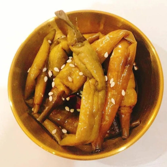 A gold bowl containing pickled Korean green chili peppers in a soy-based sauce, a traditional side dish known as Gochu Jangajji.