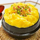 Korean steamed egg side dish with green garnish on a woven mat