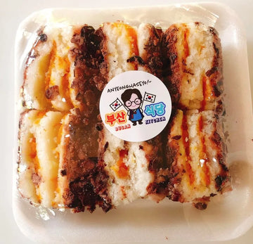 Red bean filled rice cake with a visible brand sticker on a white background