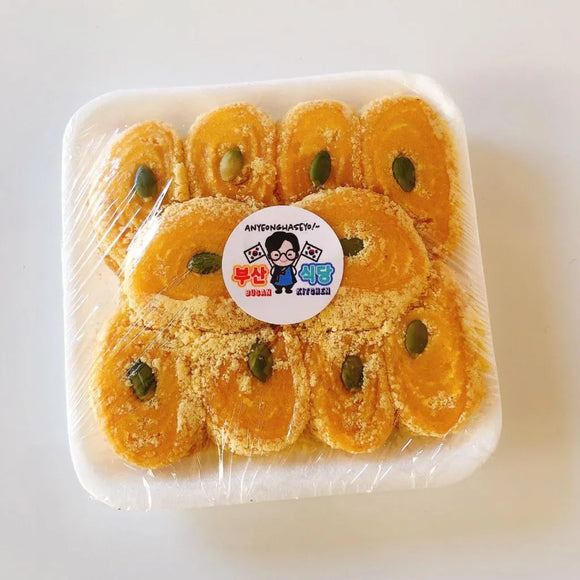 Packaged golden rice cake with pumpkin filling with a cartoon character label on a white background