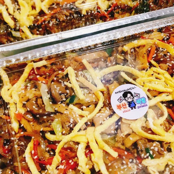 Plastic container of noodles with a visible brand sticker on a clear background