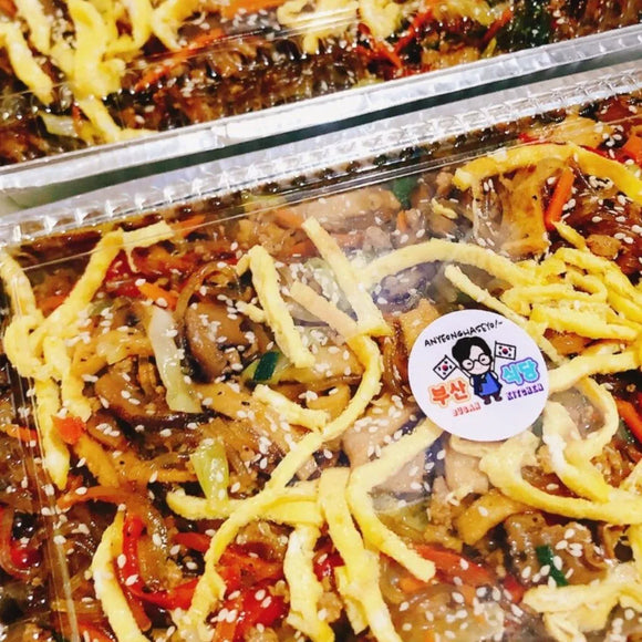 Plastic container of noodles with a visible brand sticker on a clear background