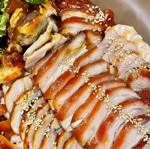 Sliced roasted pork with sesame seeds on a plate