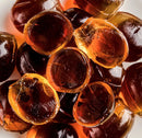 Close-up of amber-colored Jeju Mandarin Korean jellies on a white background