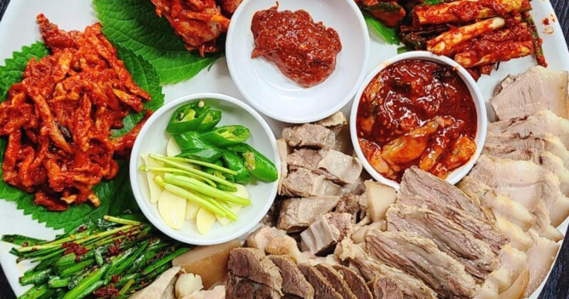 Assorted Korean dishes including kimchi, meats, and vegetables on a platter.