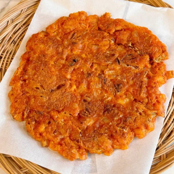 Kimchi pancake on a white paper with a woven basket background