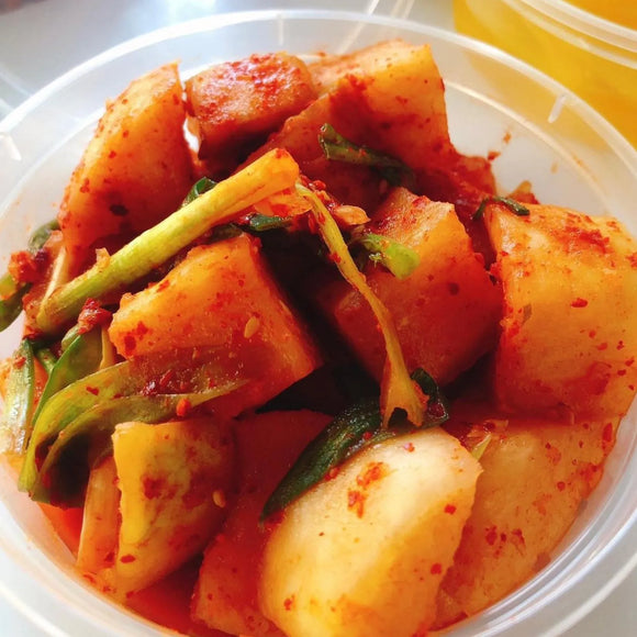 A bowl of Kkakdugi, which is a Korean side dish made from spicy pickled daikon radish, typically served as a banchan.