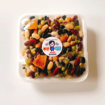 Rice cake with assorted dried fruits in a container with a visible brand label on a white background