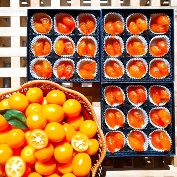 Basket and boxes of Kumquat Jelly on a wooden surface