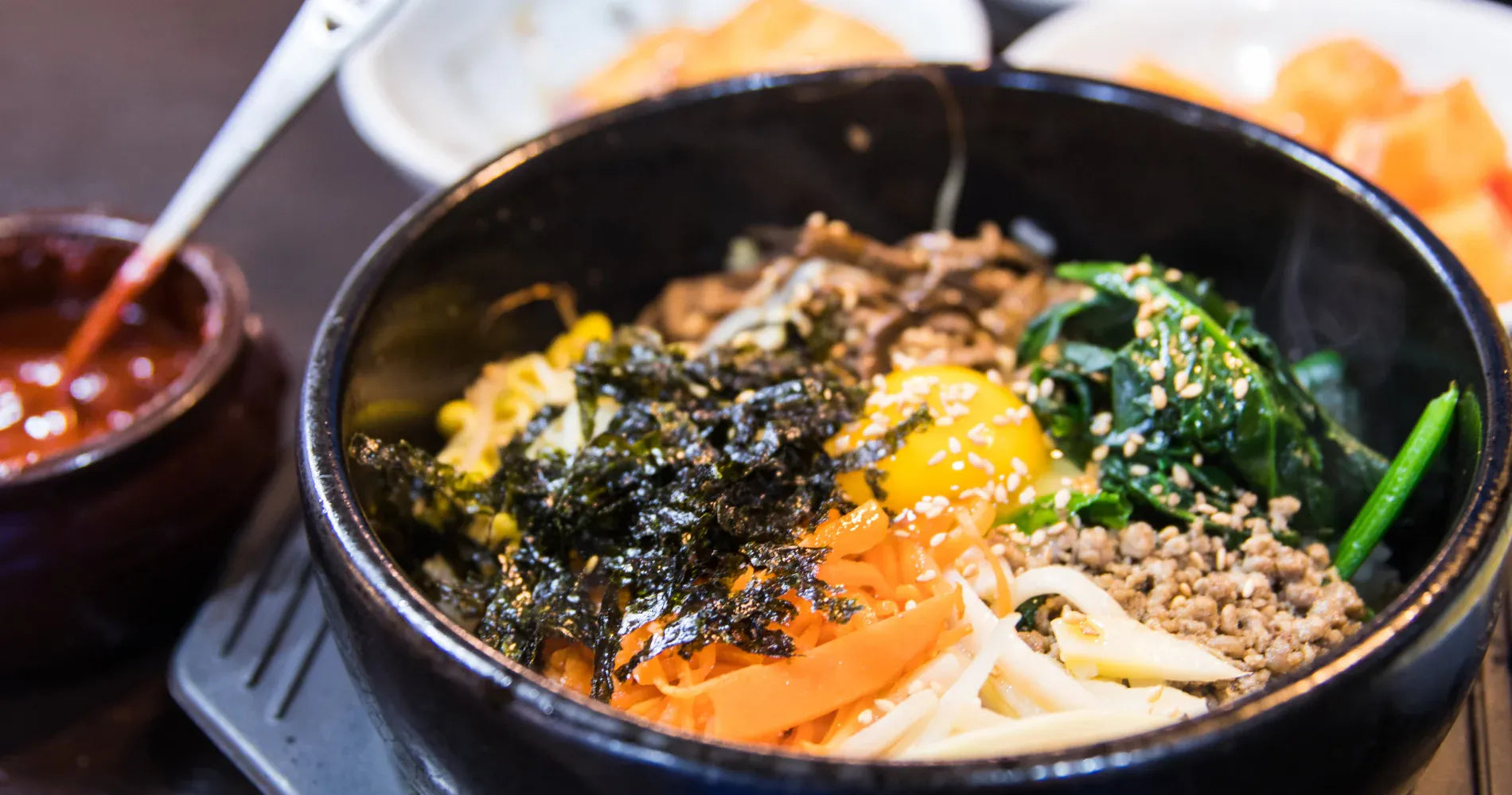 Bowl of Korean cuisine with various ingredients on a wooden table