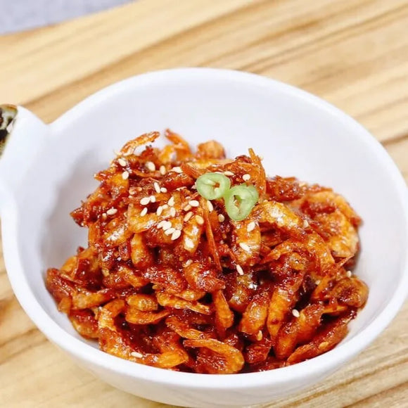White bowl filled with Korean dried shrimp side dish on a wooden surface