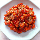 Plated garlic banchan of sesame-covered food on a white plate