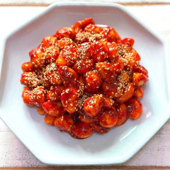 Plated garlic banchan of sesame chicken with a white background