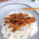 Spicy Seasoned Garlic Scrapes Banchan on a bed of white rice, served on a gray plate with chopsticks.