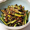 Bowl of stir-fried garlic scapes, accompanied by myeolchi (dried anchovies)