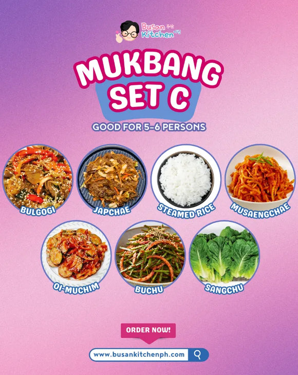 Promotional image of a Mukbang set with various Korean dishes on a pink and purple gradient background.