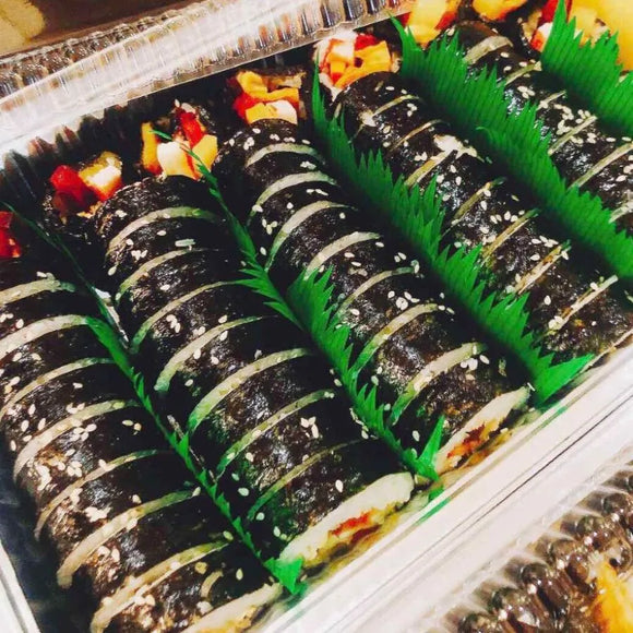 Pork Kimbap with green leaves on a tray