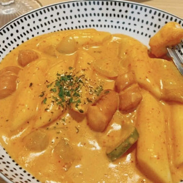 Rich, creamy, and mildly spicy tteokbokki on a polka dot plate