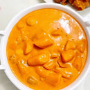 Rich, creamy, and mildly spicy tteokbokki in a white bowl on a light background