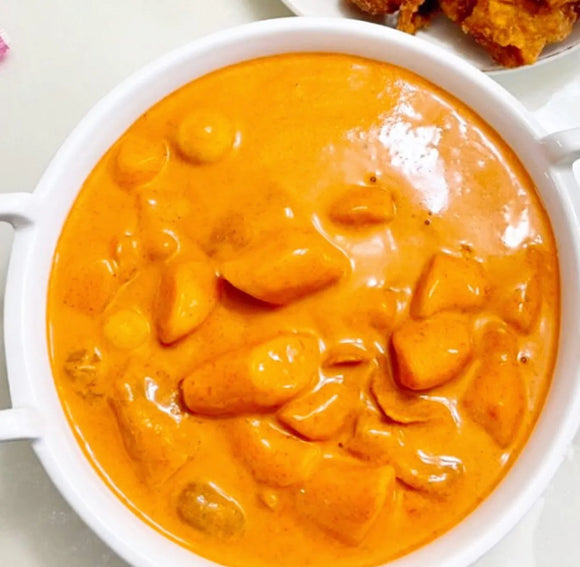 Rose tteokbokki in a white bowl on a light background