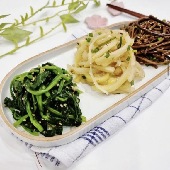 Two plates of food on a white surface with a decorative background