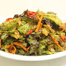 Korean lettuce salad with greens, carrots, and red peppers on a white plate.
