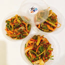 Three containers of Korean lettuce salad with a clear lid on a white background