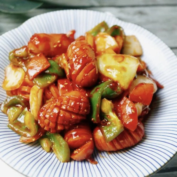 Plate of Korean stir-fry, featuring Vienna sausages with vegetables on a white plate