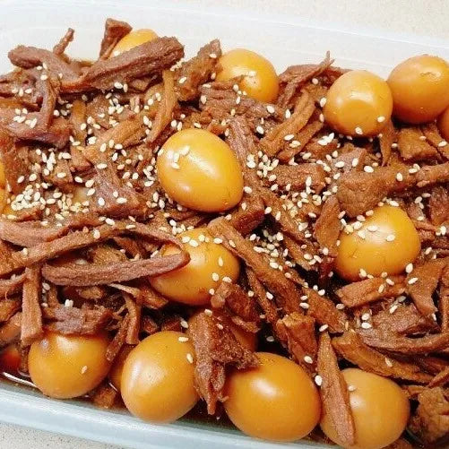 Dish with shredded braised beef and pickled eggs on a white plate