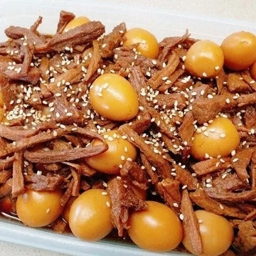 Dish with shredded braised beef and pickled eggs on a white plate