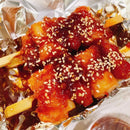 Korean street food featuring sausages and rice cakes on a skewer.