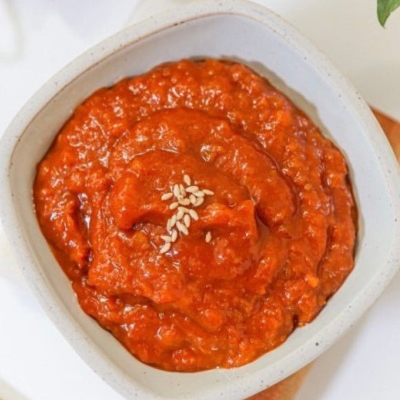 Ssamjang, an authentic Korean condiment in a white bowl with sesame seeds on top