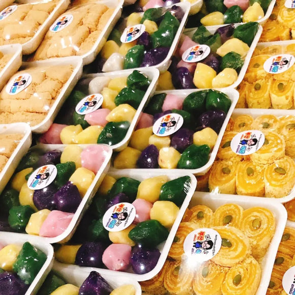 Assorted colorful Tteok (rice cake) in plastic containers with visible brand labels.