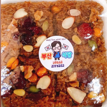 Packaged dish with rice and nuts, featuring a 'Busan Kitchen' label.