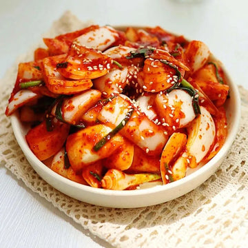 Bowl of onion kimchi on a white background