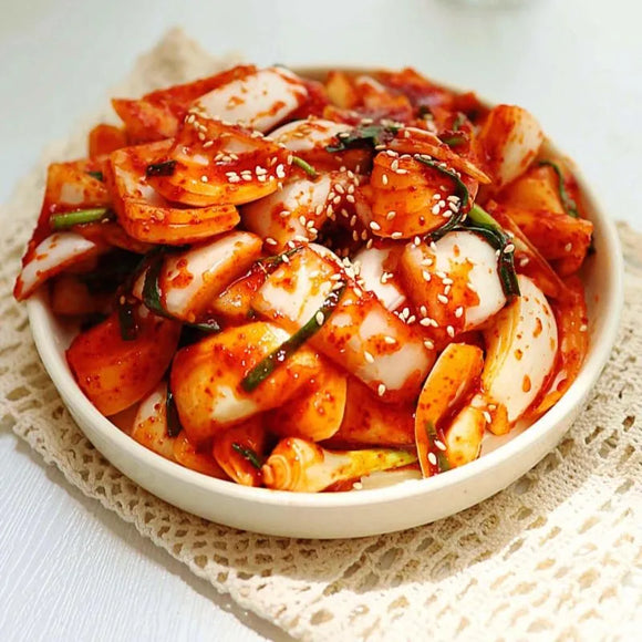 Bowl of onion kimchi on a white background