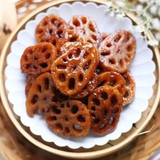 Sliced lotus roots on a white plate with a gold rim